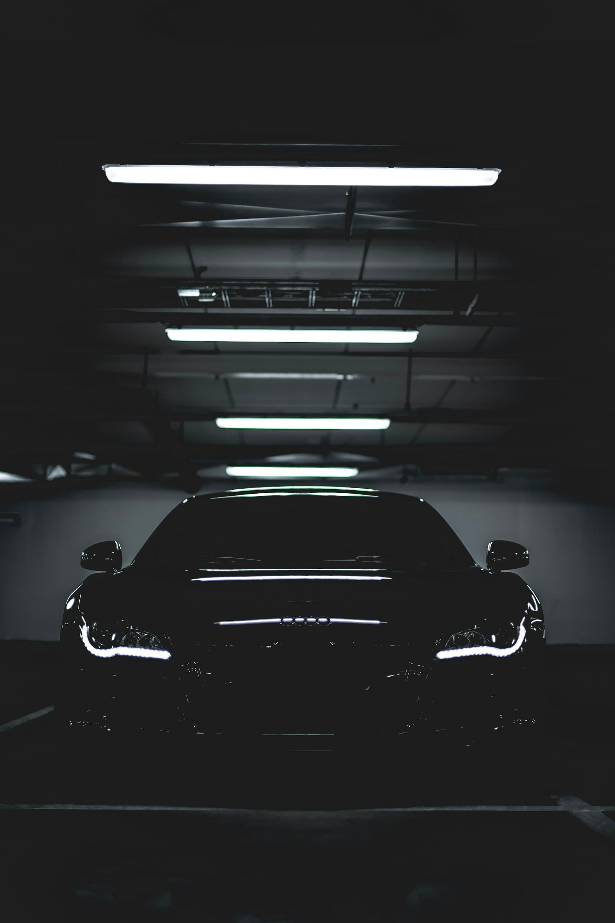 Black car parked in a lit garage