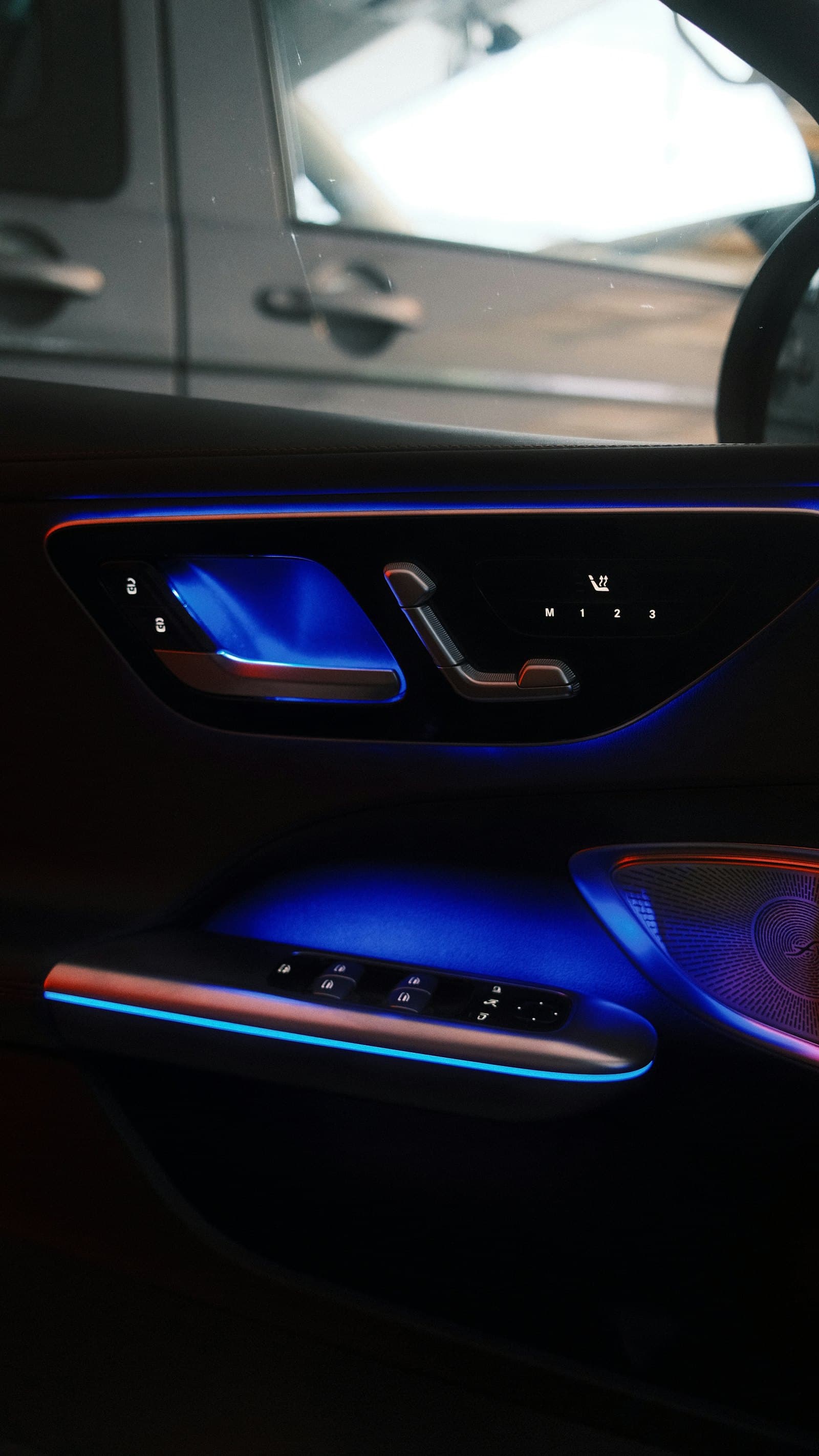 Car door interior lit with blue ambient lighting