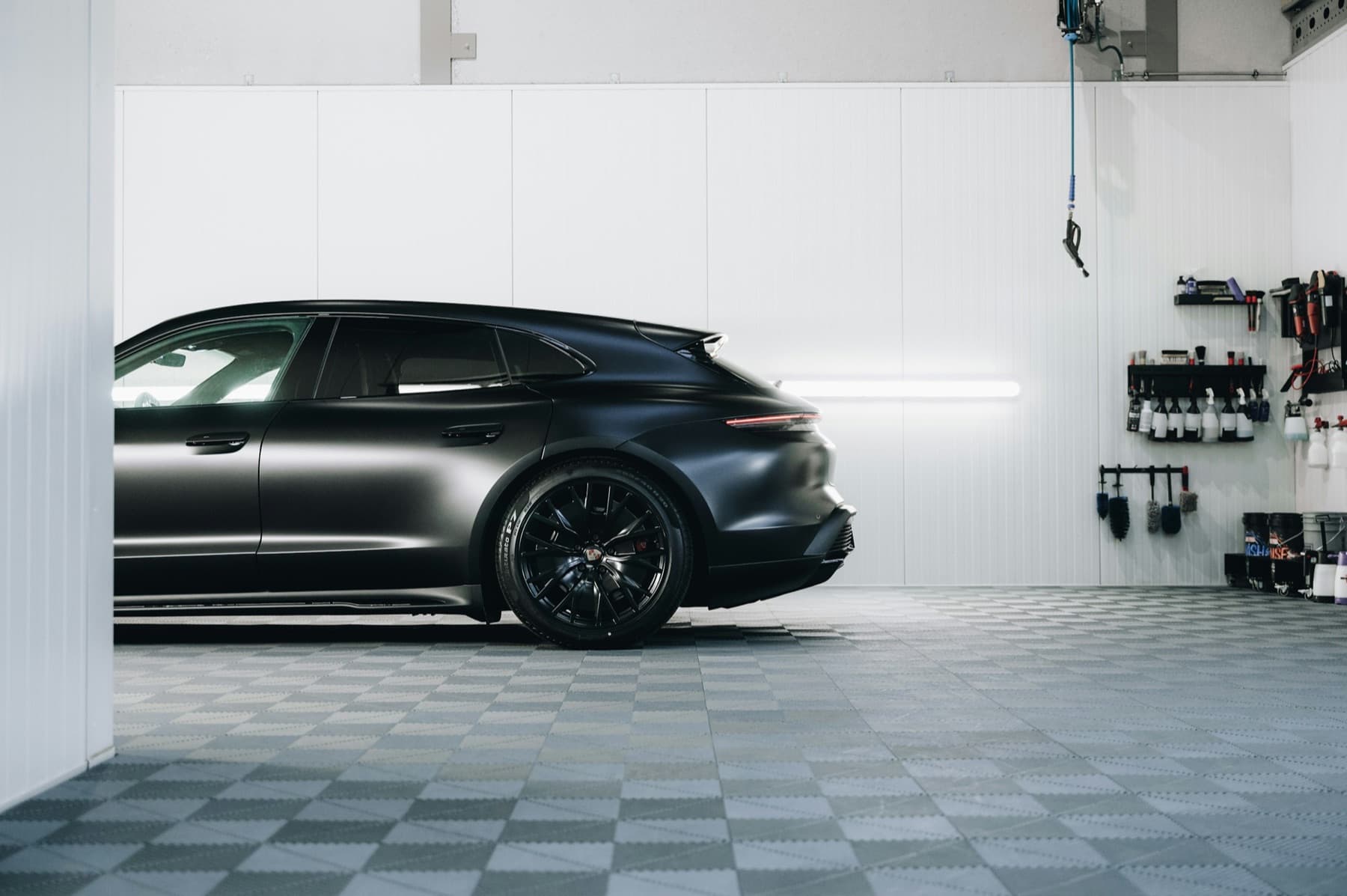 Satin black wagon parked in a bright detailing studio